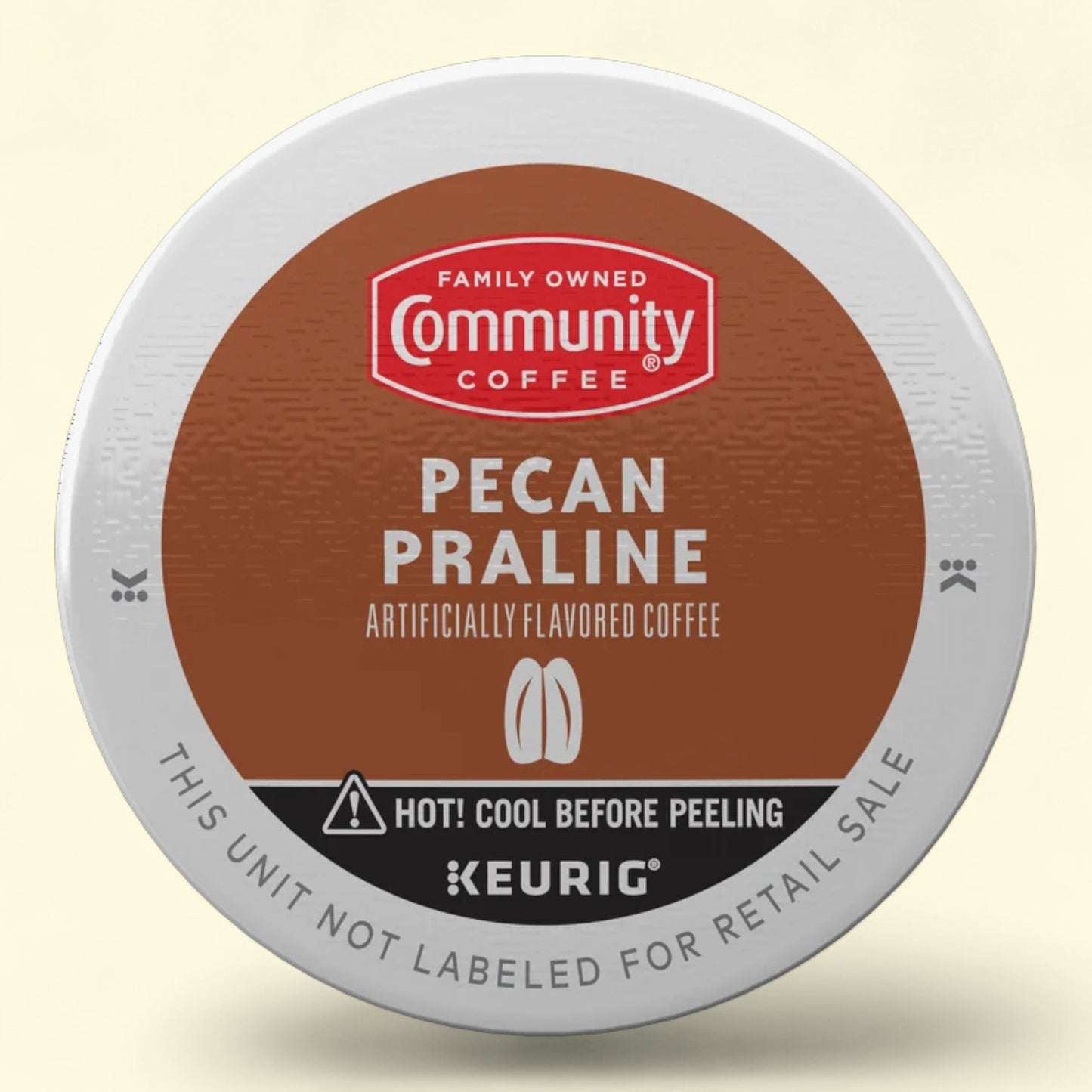 Keurig coffee pod with Community Coffee branding on a beige background