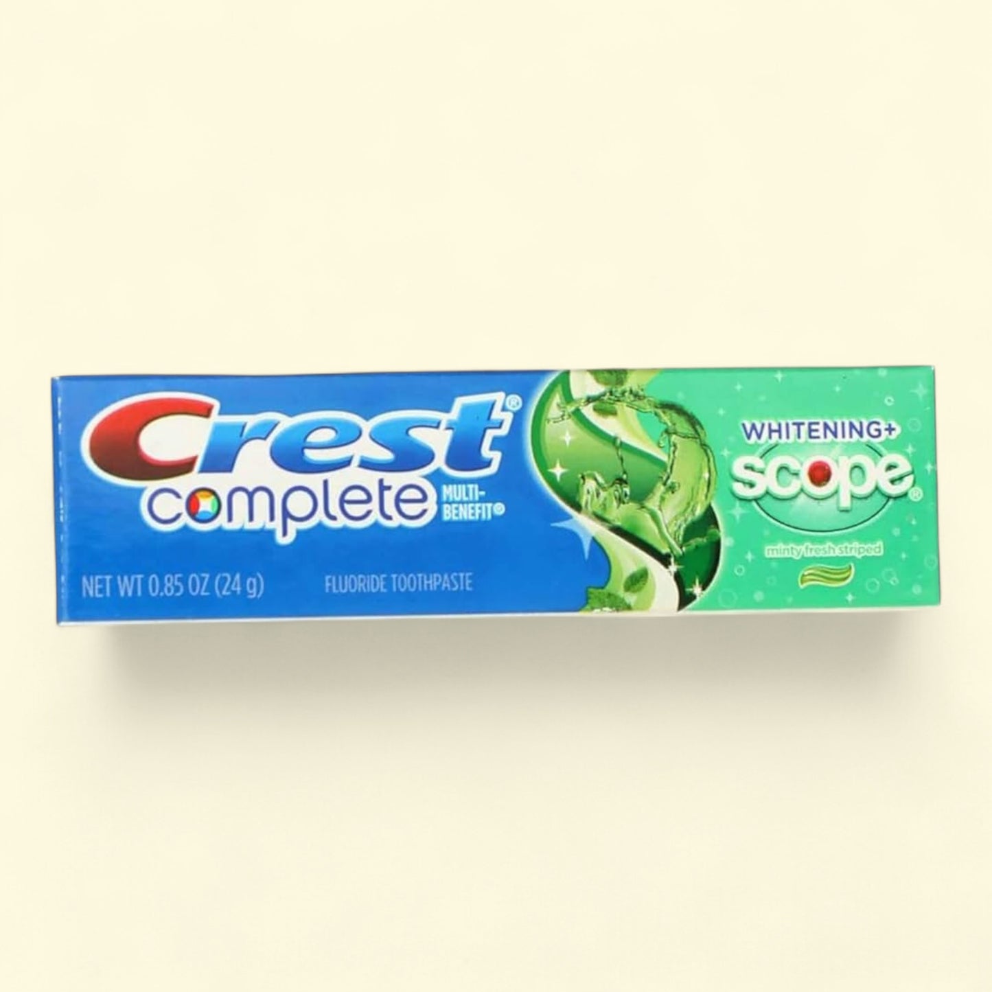 Crest Complete Whitening + Scope toothpaste tube on a beige background