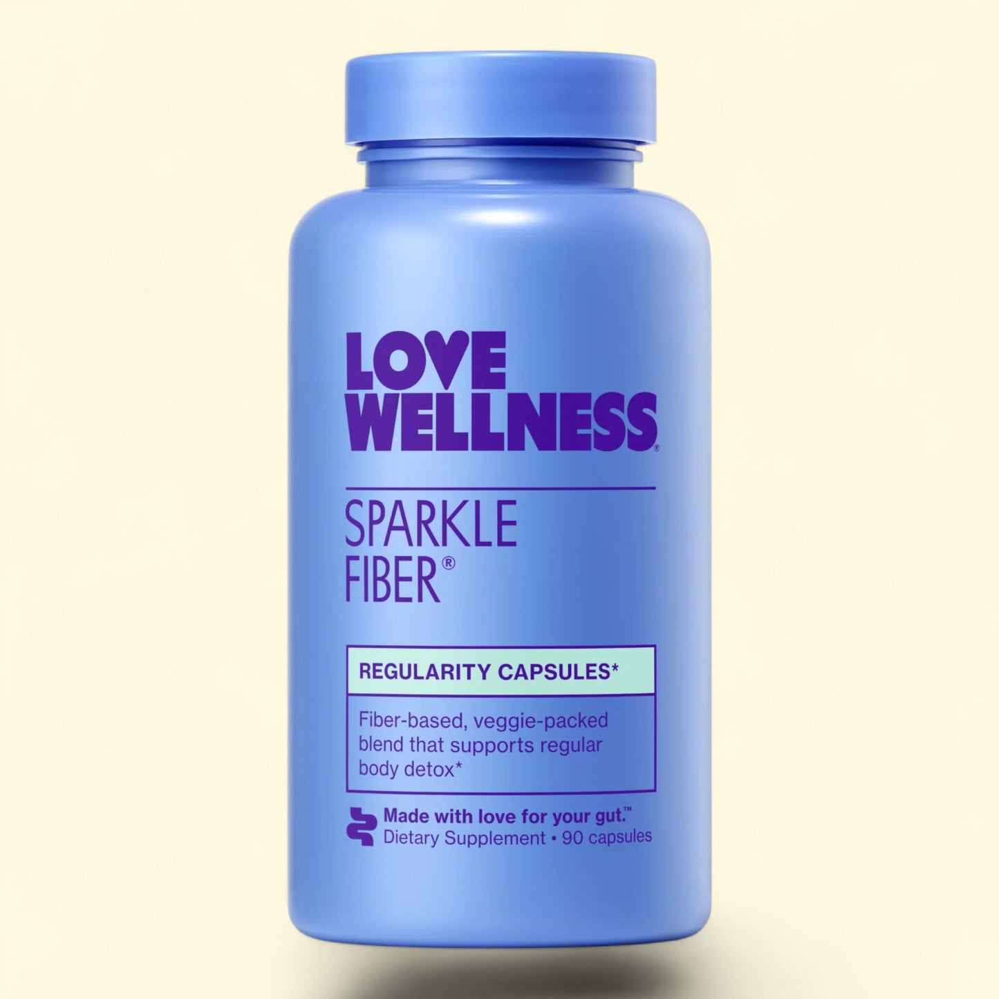 Blue supplement bottle labeled 'Love Wellness Sparkle Fiber' on a beige background