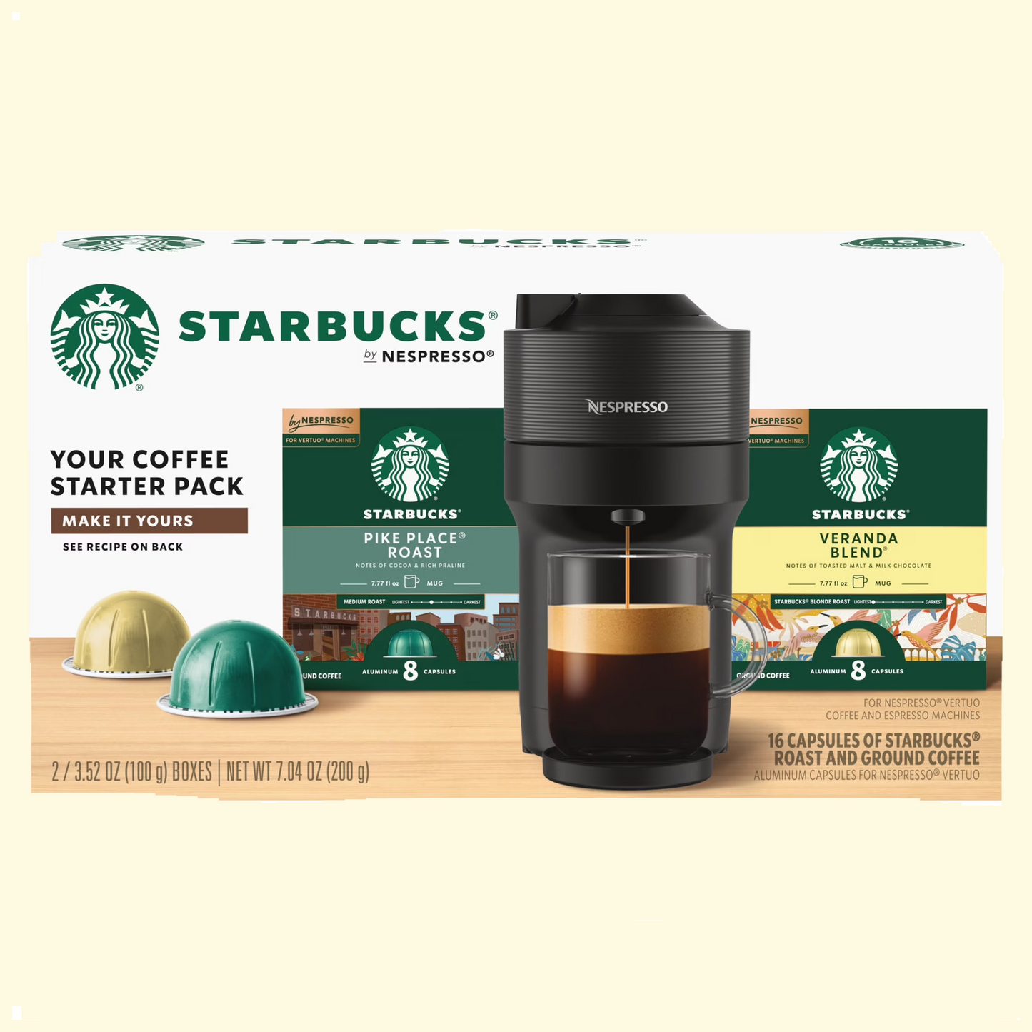 Starbucks by Nespresso coffee starter pack with coffee machine and capsules on a wooden surface.