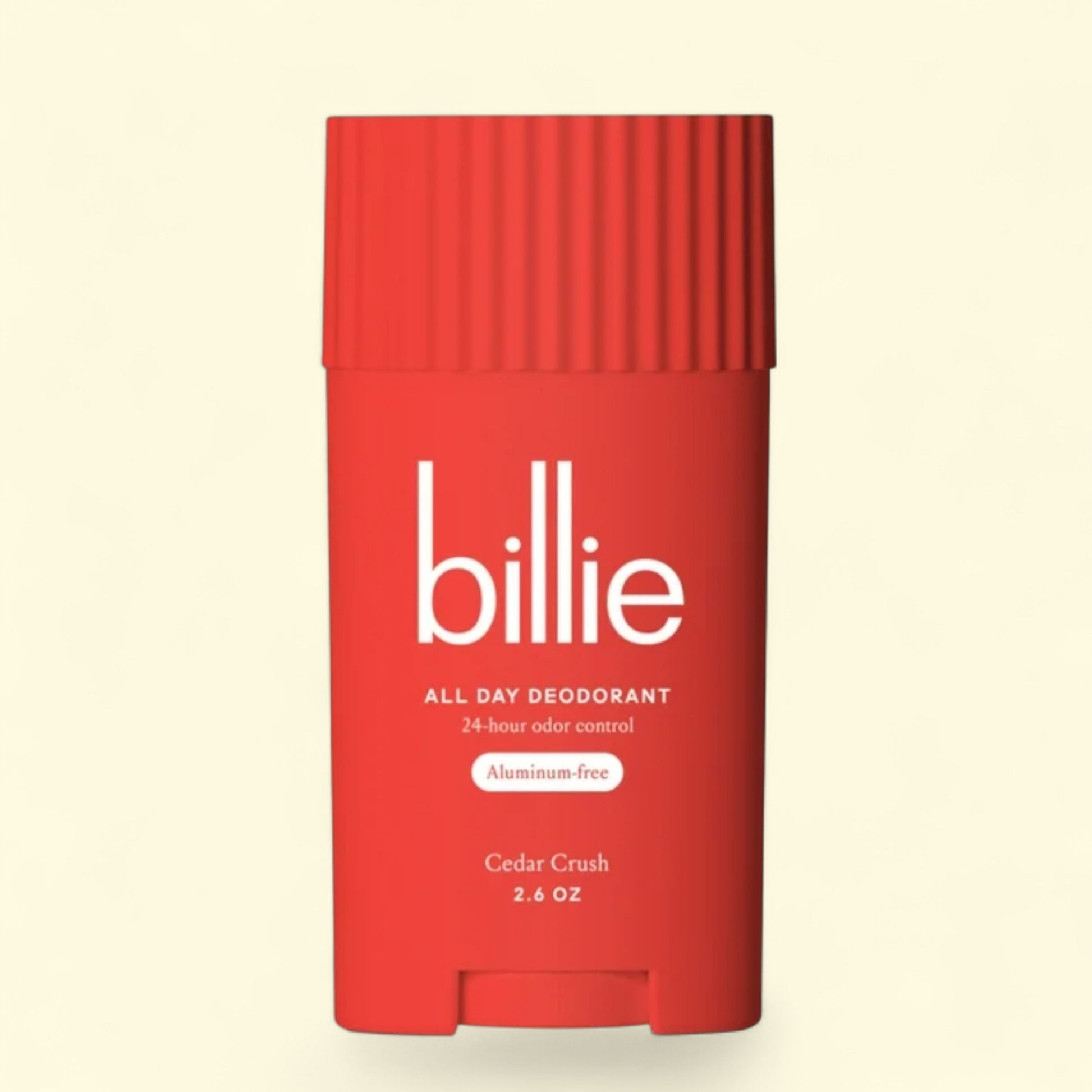 Red deodorant stick with 'billie' branding on a beige background