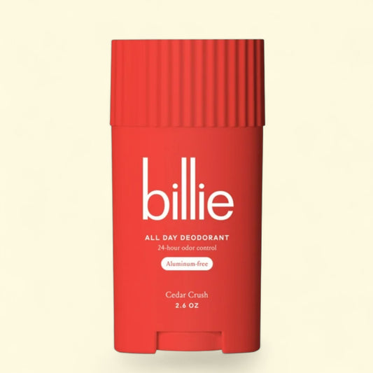 Red deodorant stick with 'billie' branding on a beige background