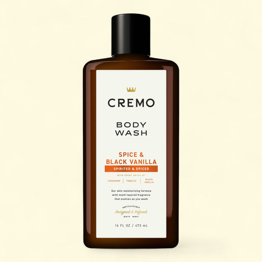 Cremo Spice & Black Vanilla body wash bottle on a beige background
