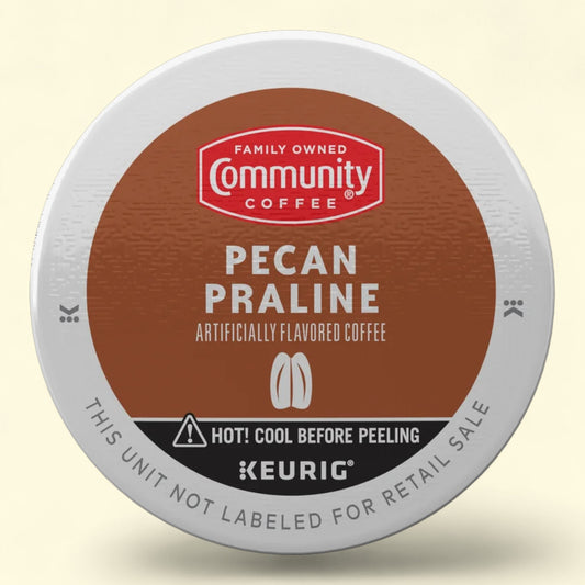 Keurig coffee pod with Community Coffee branding on a beige background