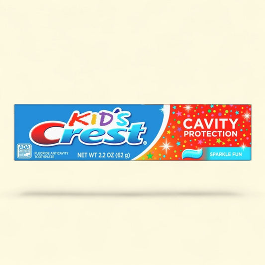 Tube of Kids' Crest cavity protection toothpaste on a beige background