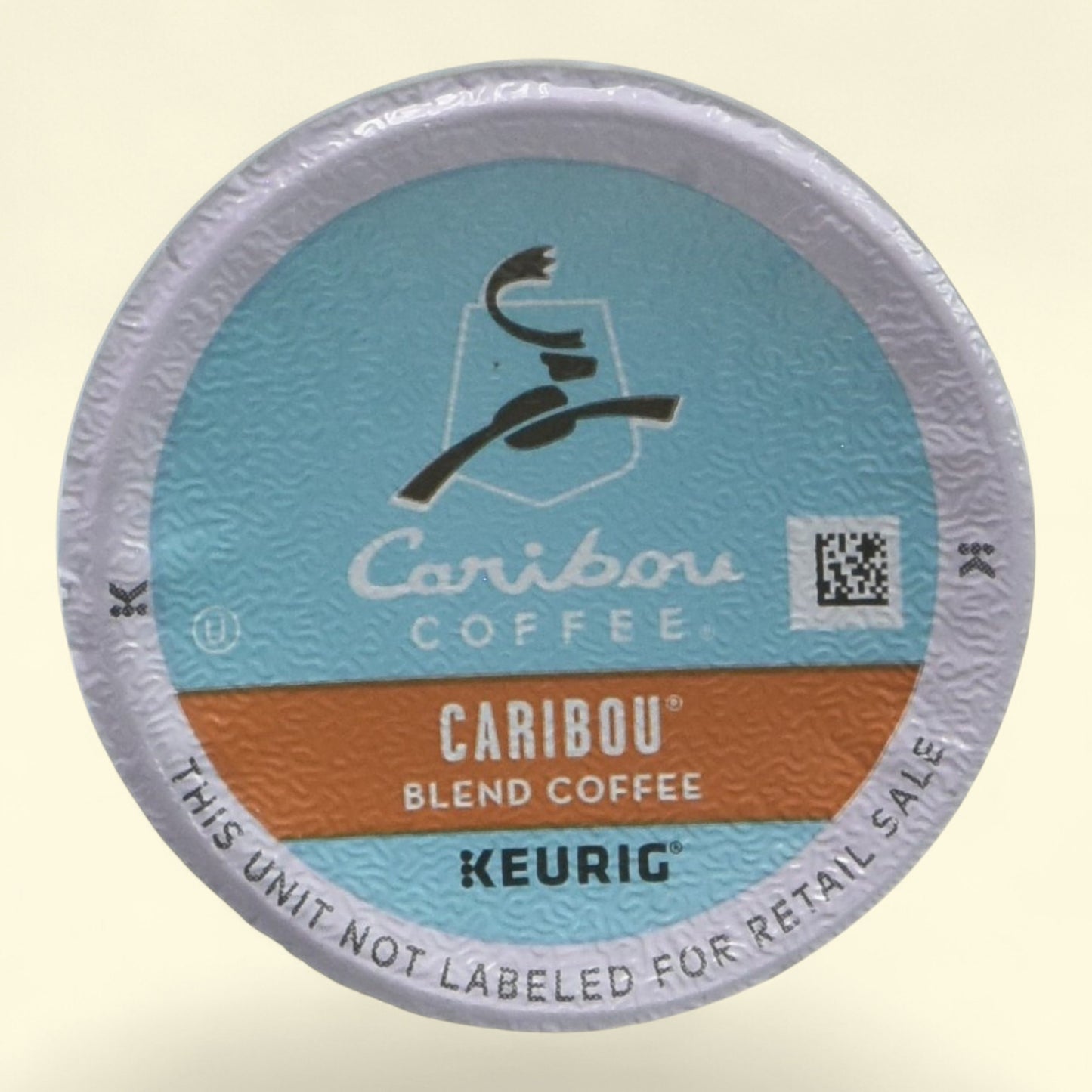 Caribou Coffee K-Cup packaging on a beige background