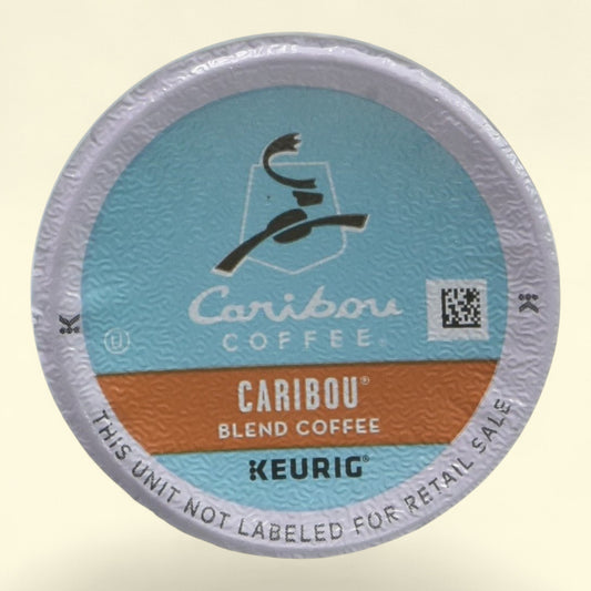 Caribou Coffee K-Cup packaging on a beige background