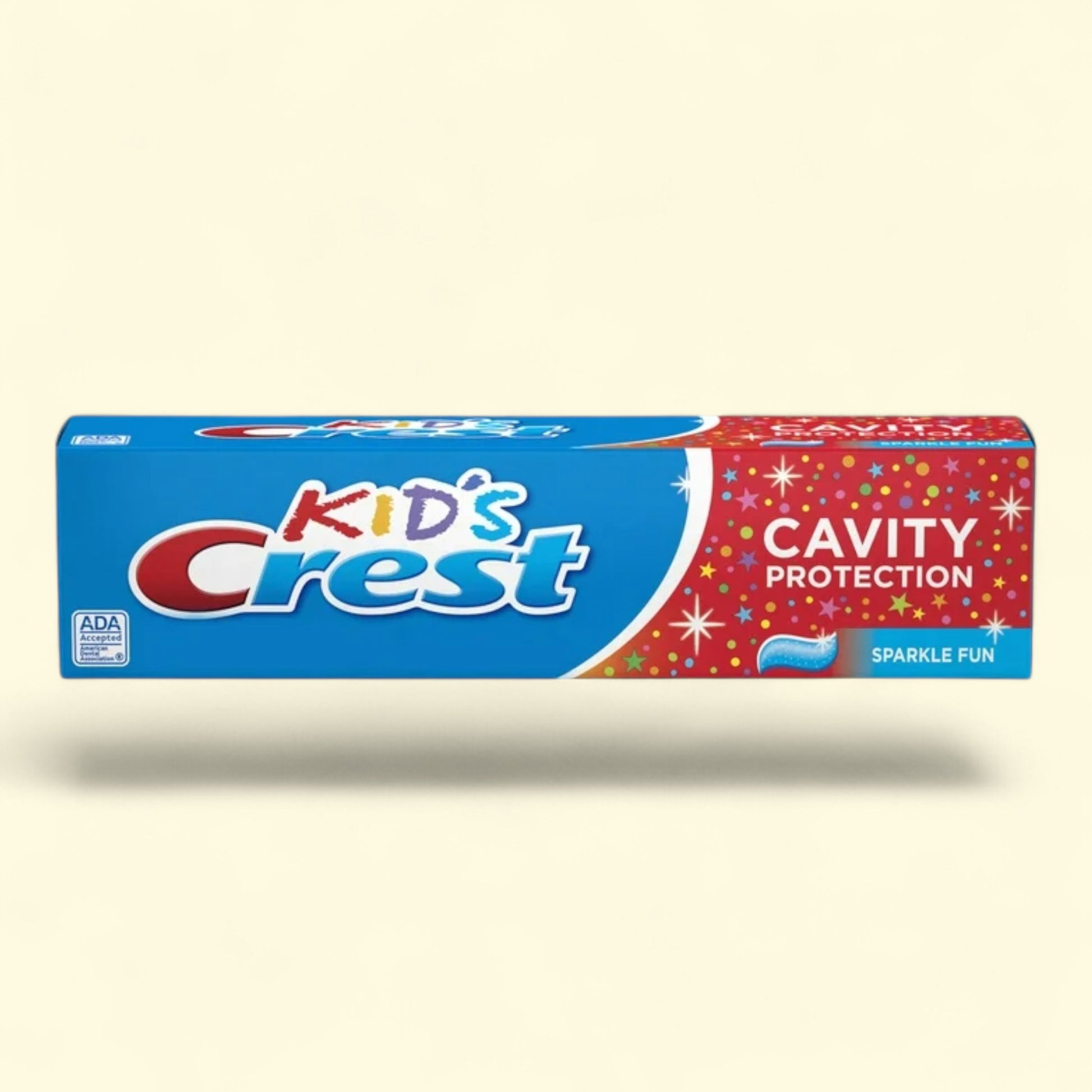 Tube of Kids Crest toothpaste on a beige background