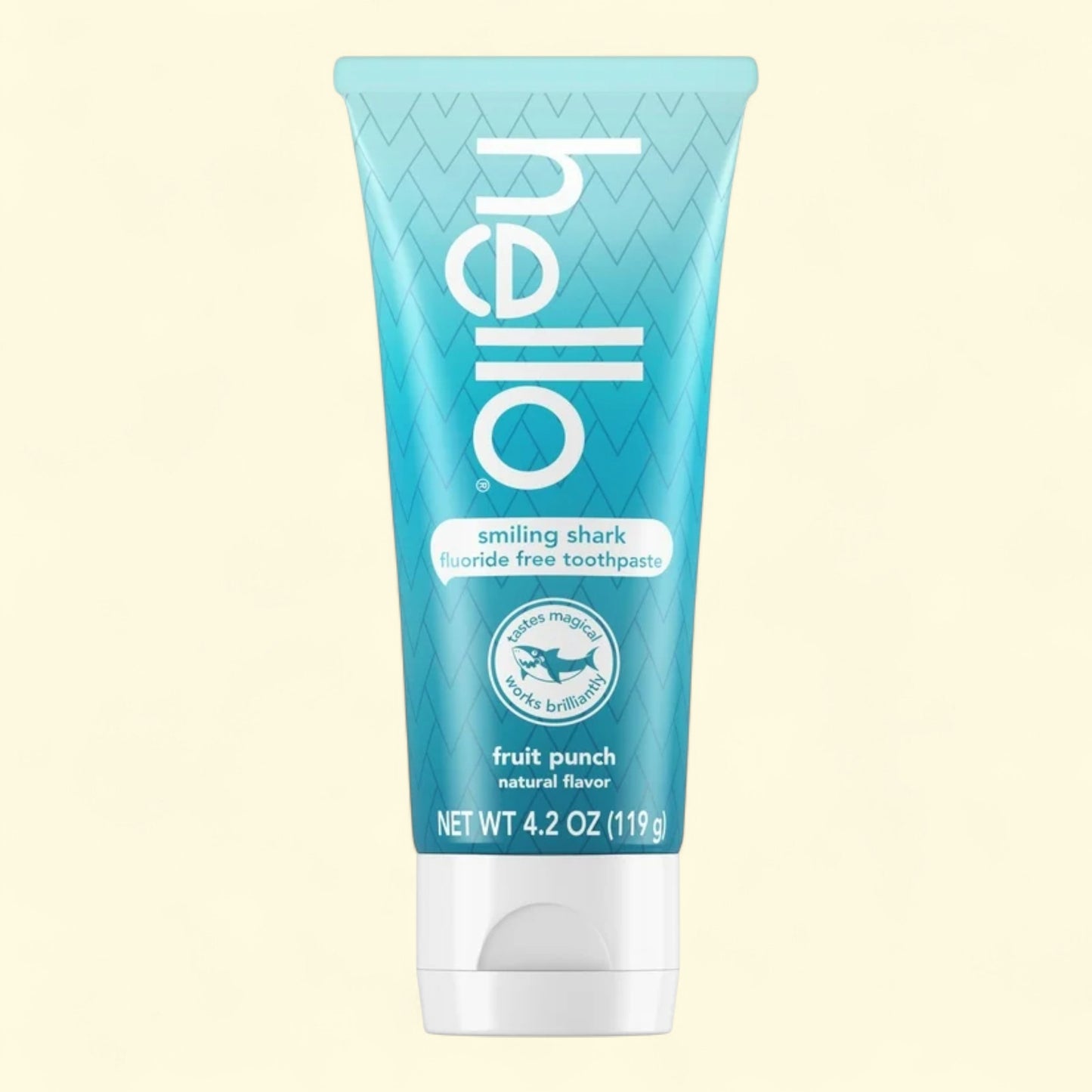 Blue tube of 'hello' smiling shark fluoride-free toothpaste on a beige background