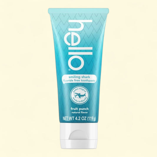 Blue tube of 'hello' smiling shark fluoride-free toothpaste on a beige background