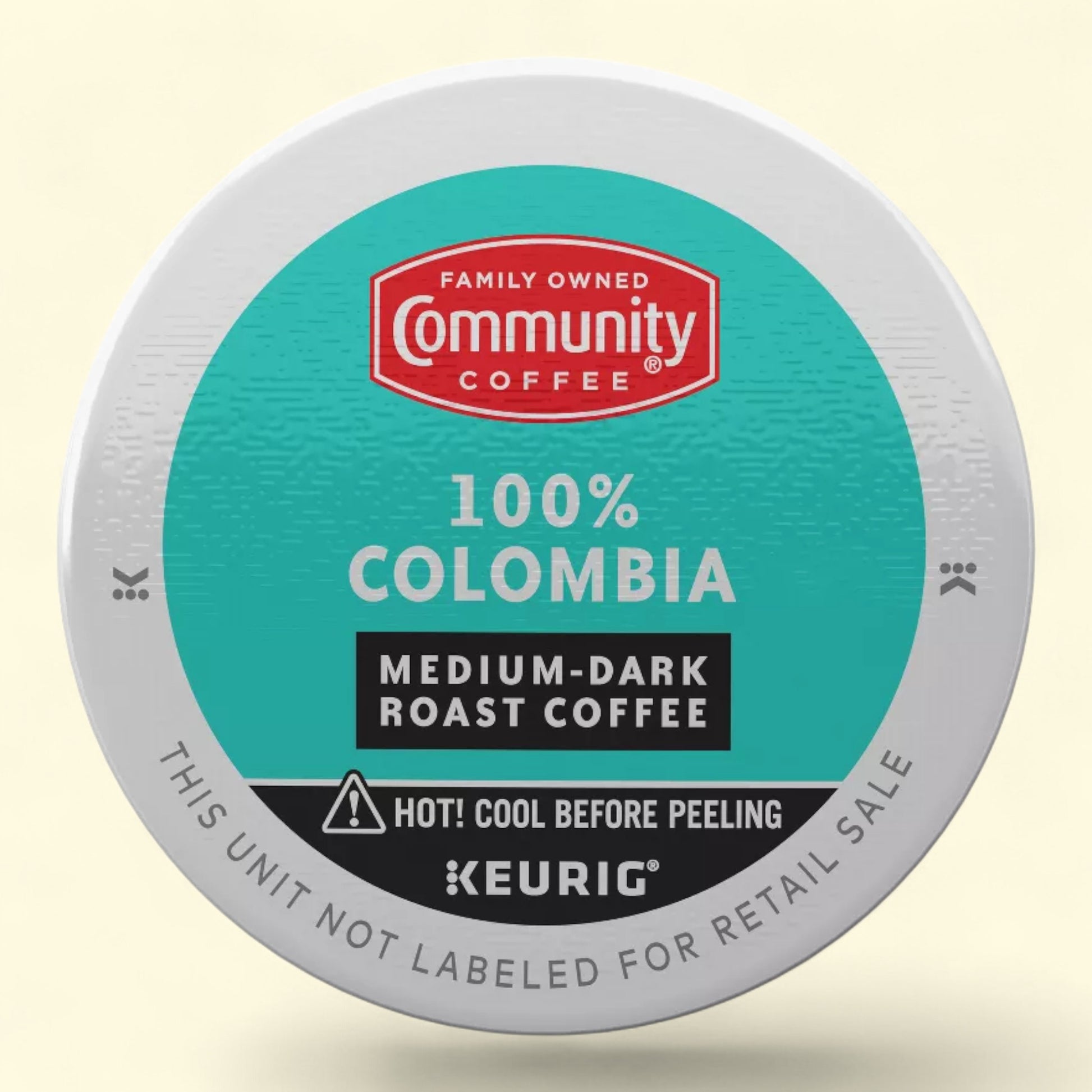 Keurig medium dark roast coffee with Community Coffee 100% colombia branding on a light beige background