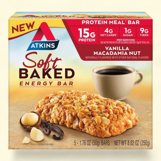 Atkins soft baked energy bar packaging with vanilla macadamia nut flavor, showing a cookie and cup of coffee on a wooden surface.