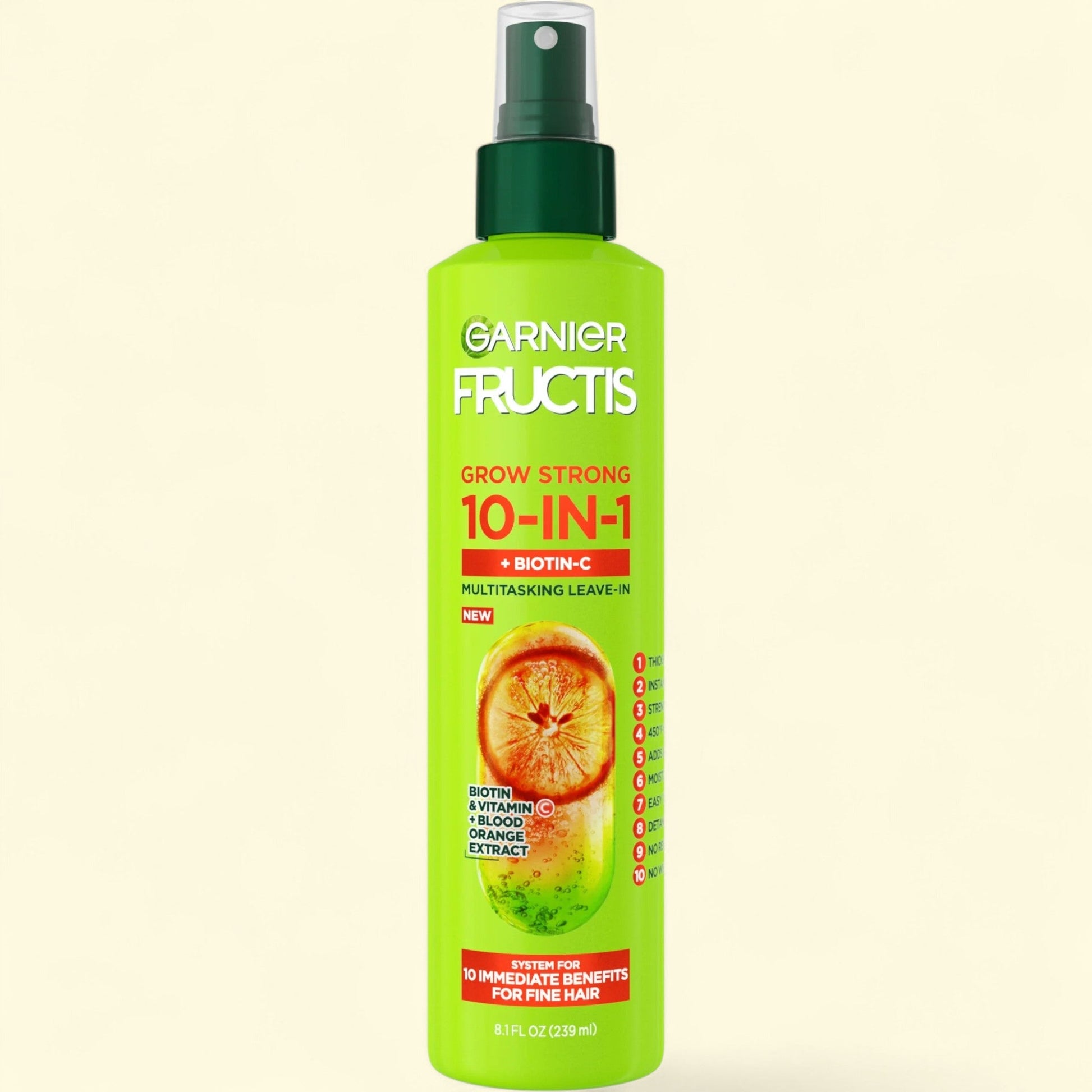 Garnier Fructis 10-in-1 hair product spray bottle on a beige background