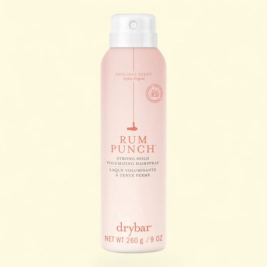 Drybar Rum Punch hair spray bottle on a light pink background