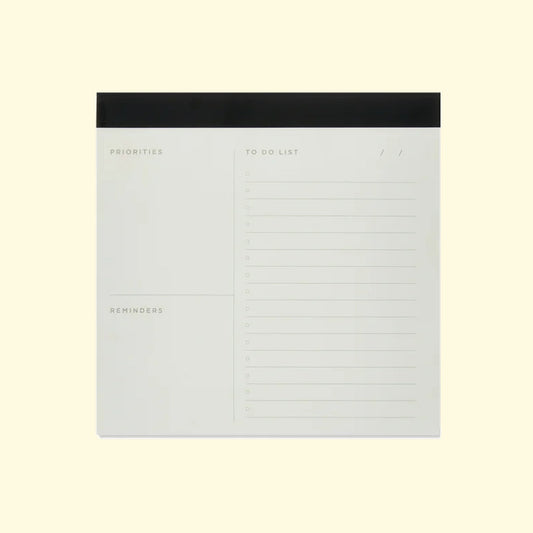 Notebook with sections for priorities, to-do list, and reminders on a light