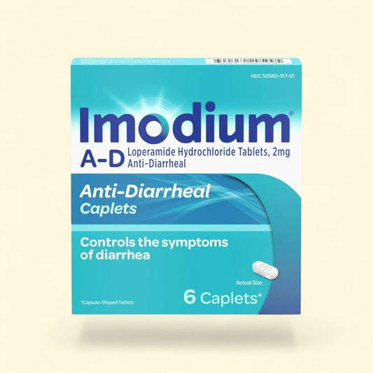Imodium A-D anti-diarrheal caplets packaging on a beige background