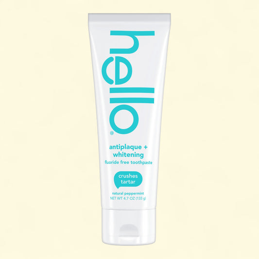 Tube of 'hello' antiplaque + whitening toothpaste on a light yellow background