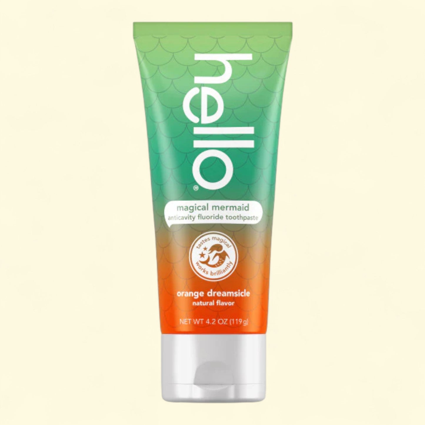 Tube of 'hello' magical mermaid toothpaste with gradient design on a beige background