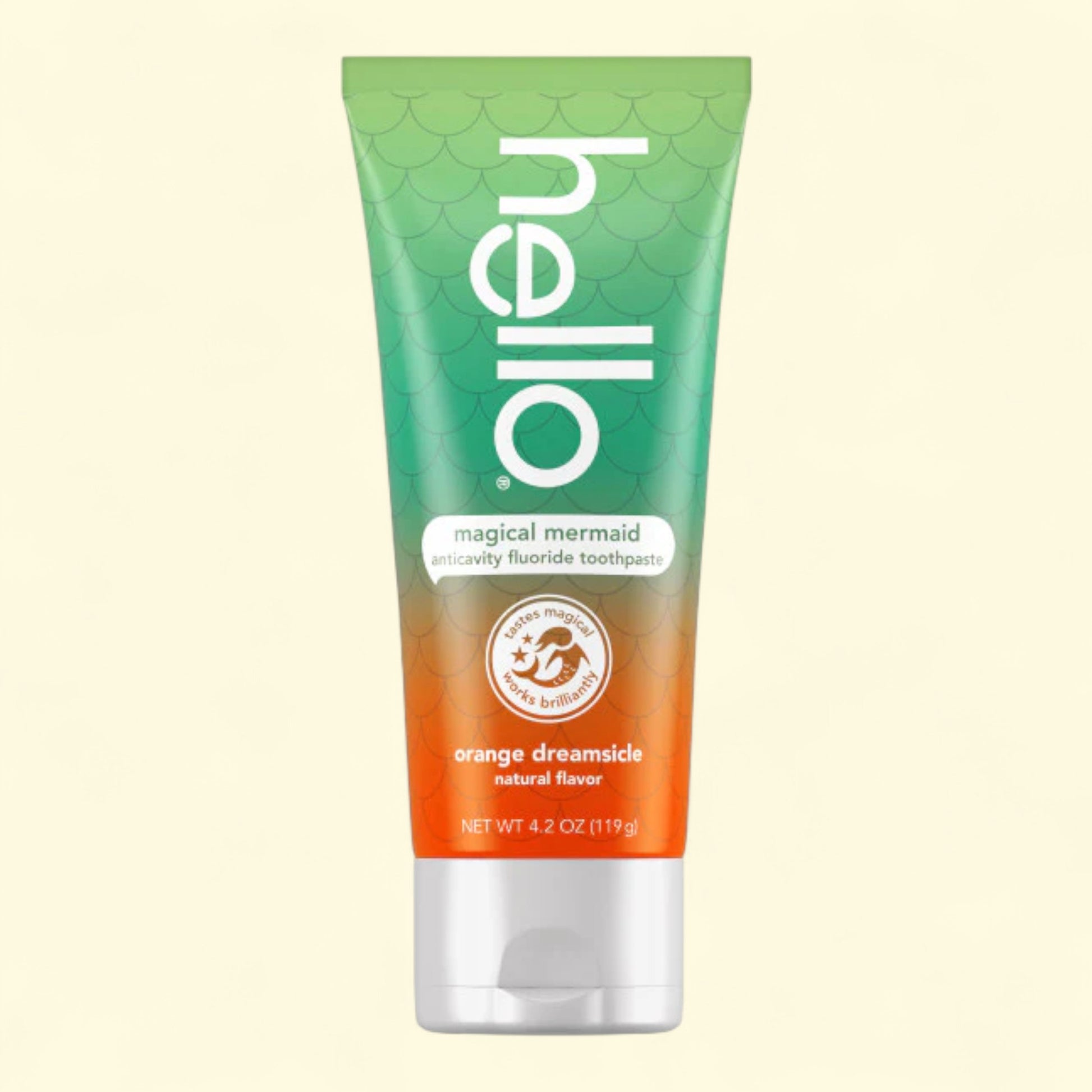 Tube of 'hello' magical mermaid toothpaste with gradient design on a beige background