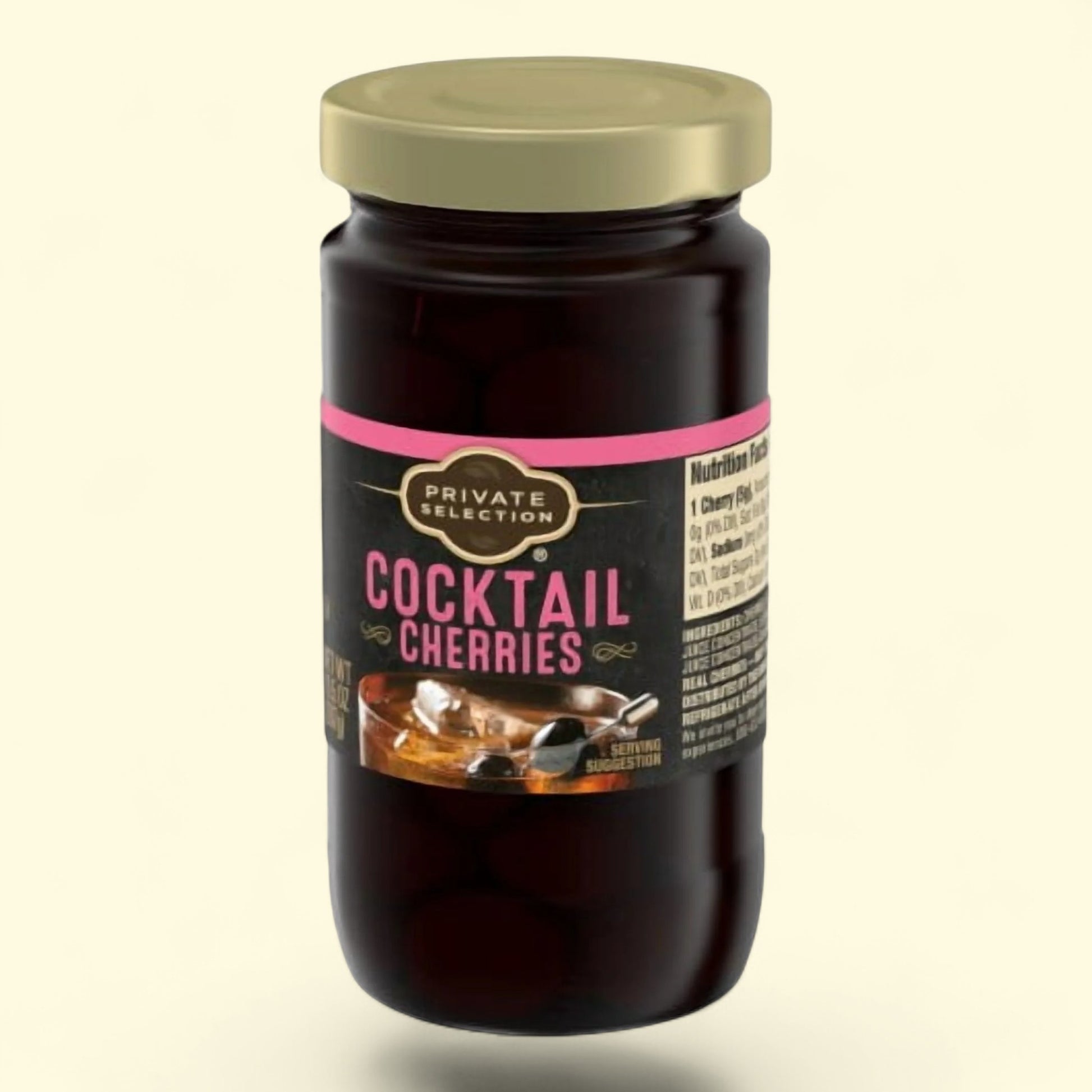 Jar of cocktail cherries with a gold lid on a beige background