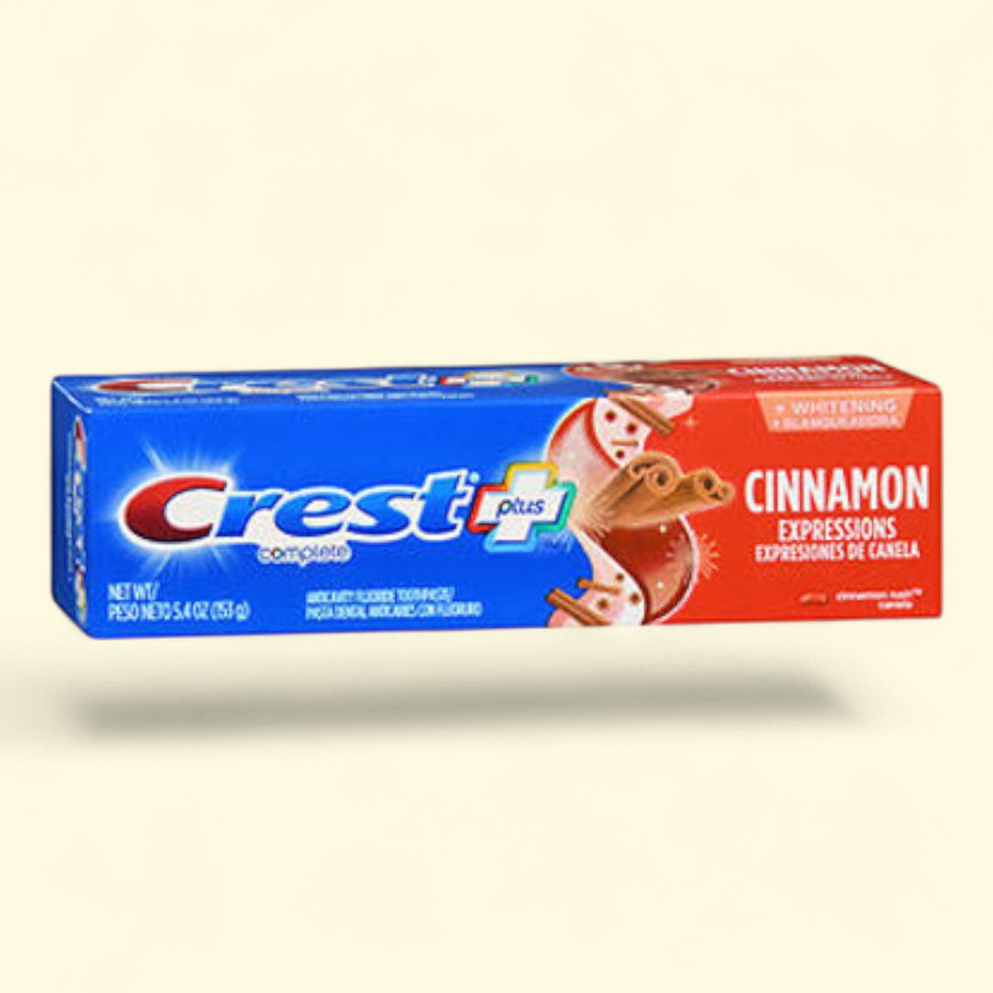 Crest cinnamon flavored toothpaste packaging on a beige background